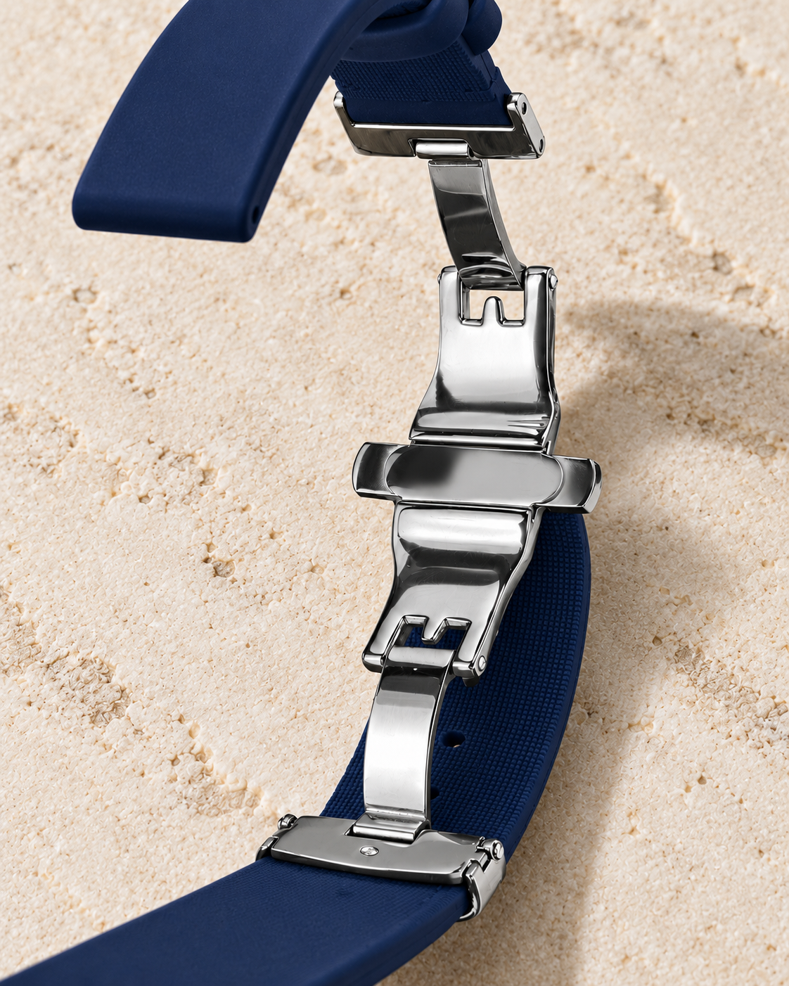 Close-up of the smooth navy Rimbo rubber strap, two keepers and RUMOE silver pin buckle